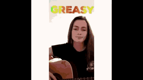 a girl is holding a guitar in front of a rainbow sign that says greasy
