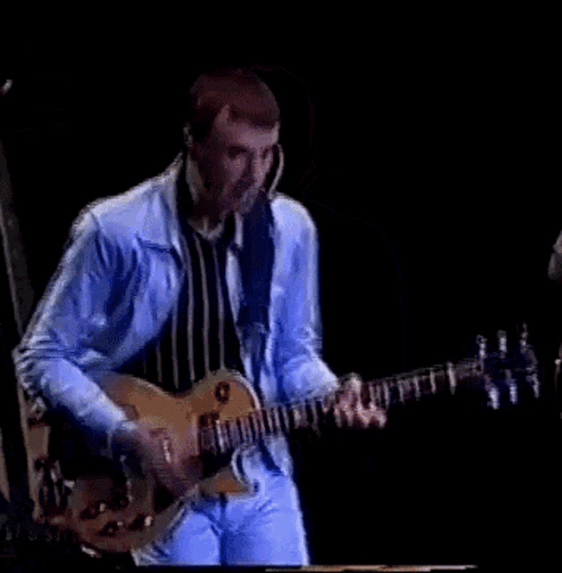 a man playing a guitar with a microphone on his head
