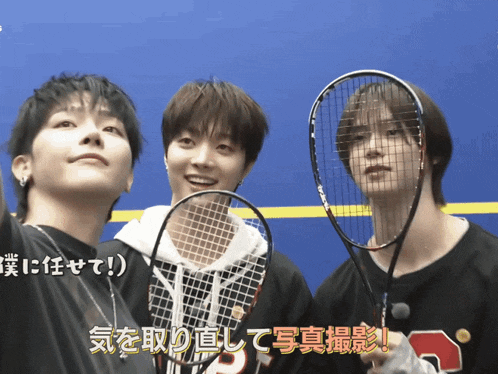a group of young men holding tennis rackets with the number 3 on their sweatshirt