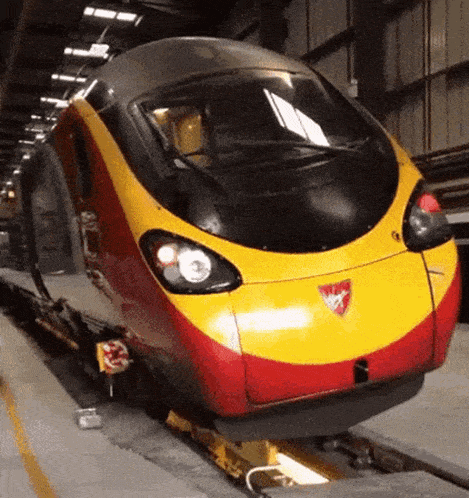 a red and yellow train with a shield on the front