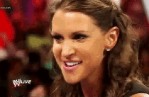 a close up of a woman 's face with the words wwe live in the background .