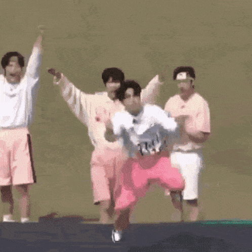a group of people are jumping on a trampoline and one of them is kneeling down .