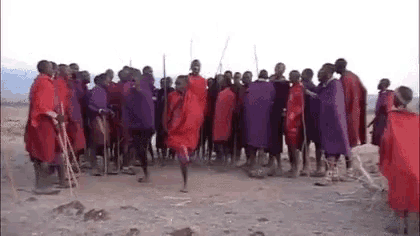 a group of african warriors are standing in a circle in the desert .