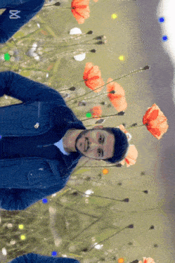 a man stands in a field of red flowers with the letter x on his sleeve