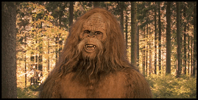 a large brown monster with a beard is standing in a forest
