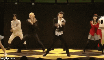a group of people are dancing on a stage with a skull and crossbones shirt on