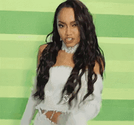 a woman with long black hair is wearing a white top and gloves .
