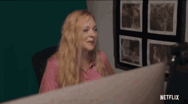 a woman is sitting at a desk in front of a computer monitor .