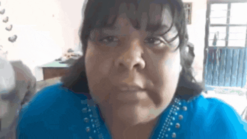 a close up of a woman 's face in a blue shirt .