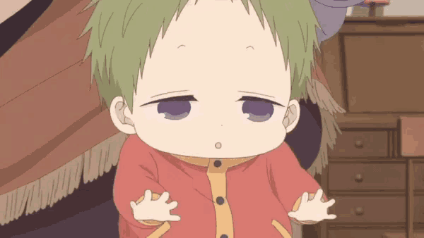 a baby with green hair is being held by a person in a red and yellow outfit .