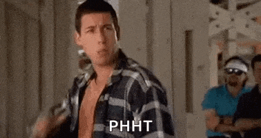 a man in a plaid shirt is standing in front of a group of men in a room .