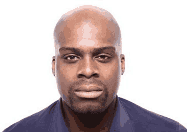 a bald man with a beard is wearing a blue shirt and looking at the camera on a white background .