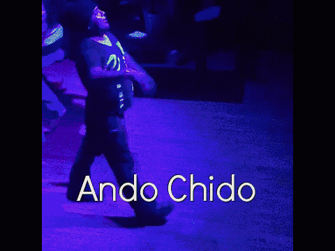 a man is dancing in a dark room with the words ando chido written above him