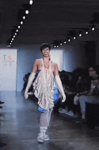 a model walks down the runway at a fashion show in front of a sign that says " i love ny "