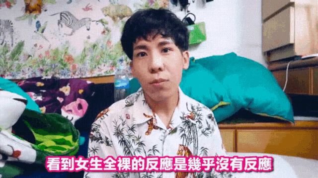 a man in a hawaiian shirt is talking in a room with chinese writing