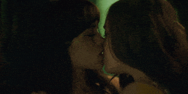 a close up of two women kissing each other