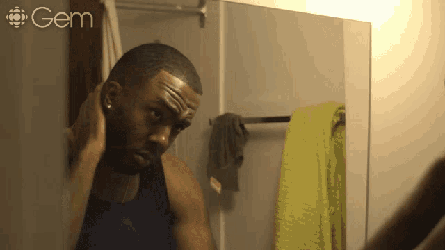 a man is looking at himself in a bathroom mirror with the word gem on the bottom