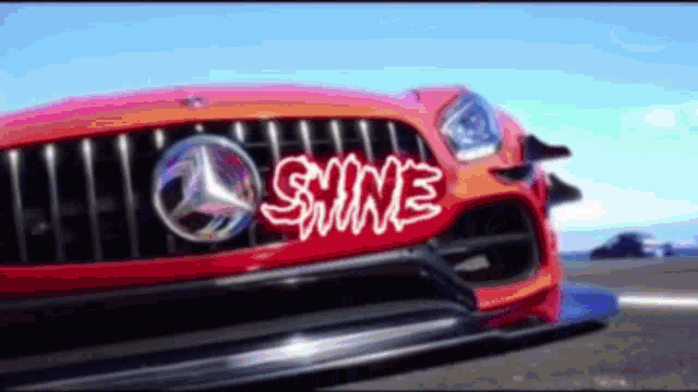 a close up of a red mercedes with the word shine on it