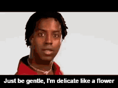 a man wearing a red shirt and a necklace is talking about being gentle .