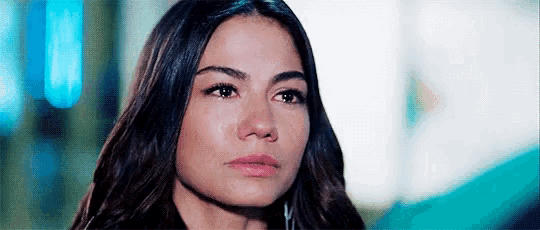 a close up of a woman 's face with a serious look on her face