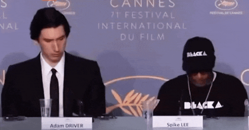 adam driver and spike lee sit at a table at the cannes international du film festival