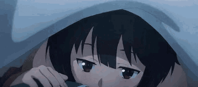 a close up of a girl laying under a blanket with her eyes closed .