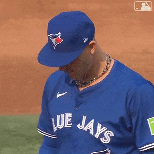 a man wearing a blue jays baseball jersey