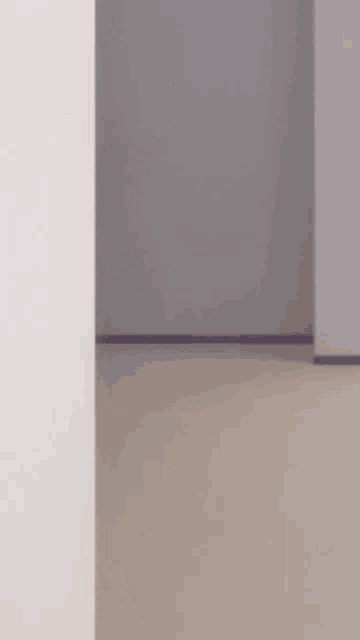 a girl with purple hair is peeking out from behind a wall .