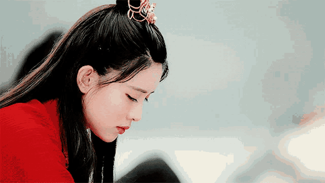 a woman in a red sweater is looking down at something