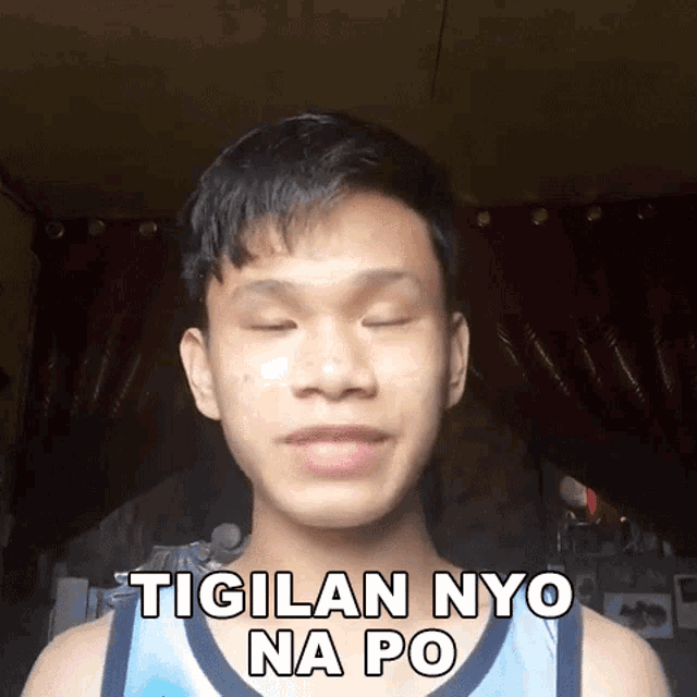 a young man with his eyes closed and the words tigilan nyo na po written on his chest