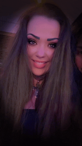 a woman with long purple hair is smiling and wearing a choker