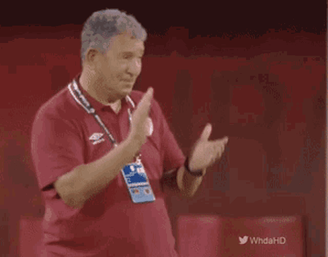 a man applauds while wearing a lanyard that says whdahd