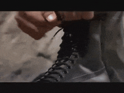 a close up of a person tying a boot .