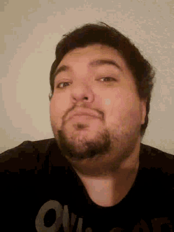 a man with a beard is wearing a black shirt that says ' supreme ' on it