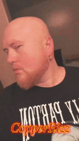 a bald man with a beard is wearing a copperrizzz shirt