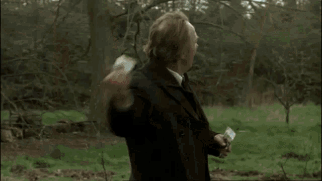 a man is kneeling in the dirt holding a bag of seeds