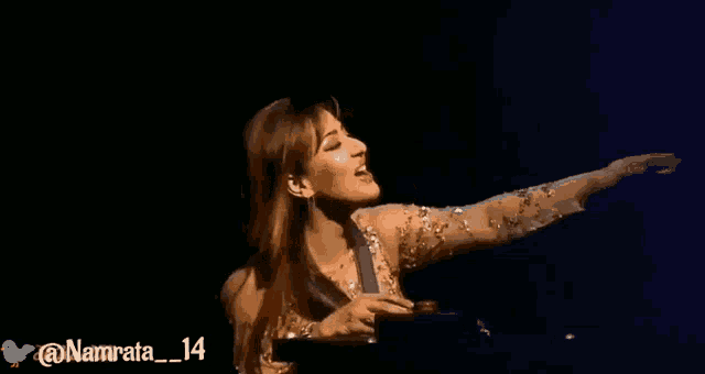 a woman singing on a stage with the hashtag namrata14