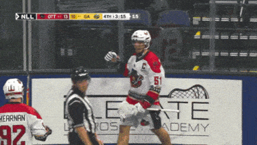 a lacrosse game is being played in front of a sign that says ' nll ' on it