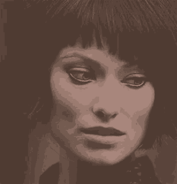 a close up of a woman 's face in a black and white photo with a fringe .