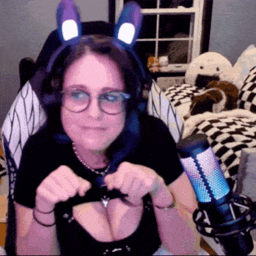 a woman wearing headphones and bunny ears looks at the camera