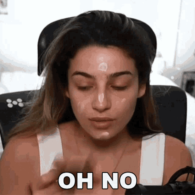 a woman is applying makeup to her face and the words oh no are on her face
