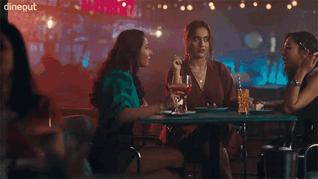 three women are sitting at a table in a restaurant with the word dineout on the bottom