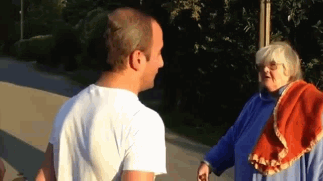 a man and a woman are standing next to each other on a street .