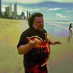 a man in a blue shirt is standing on a sandy beach