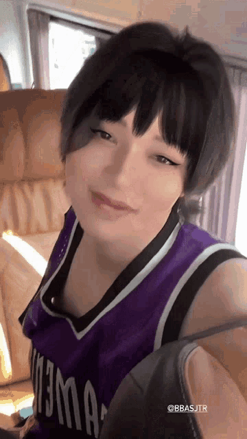 a woman wearing a purple jersey that says 13ma