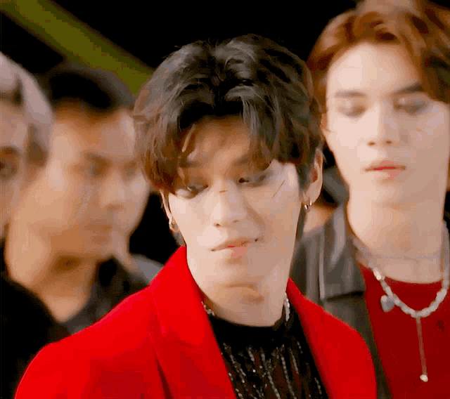 a man in a red jacket looks at the camera