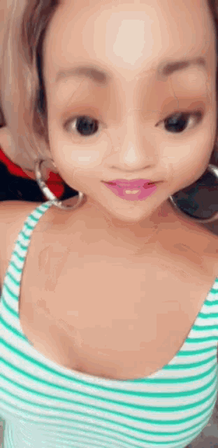 a woman wearing a striped tank top and hoop earrings is taking a selfie