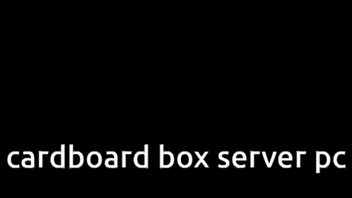 a cardboard box server pc is displayed in front of a building on fire