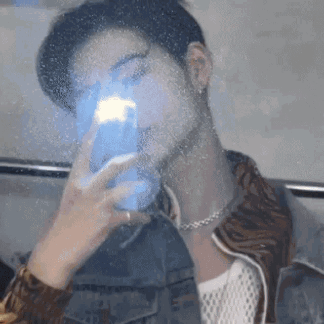 a young man is taking a picture of himself in a mirror .