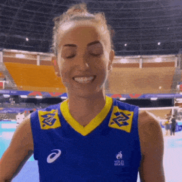 a woman wearing a blue and yellow shirt that says volei brasil